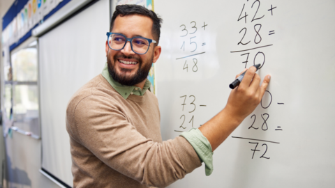 Math teacher writing on the whiteboard