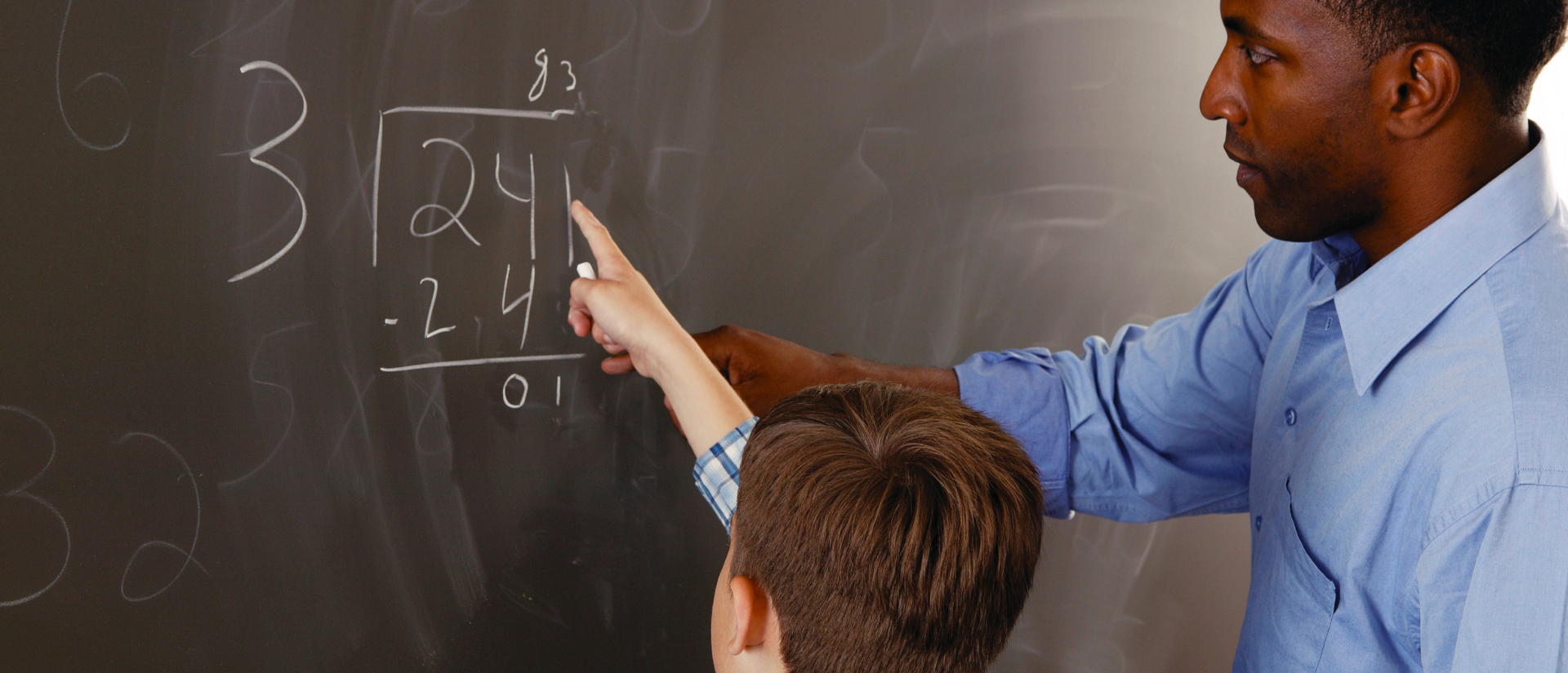 Instructor teaching student math at blackboard.